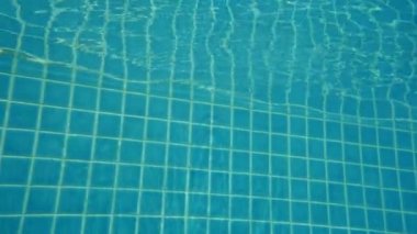 6 yaşında bir kız tatil köyünde havuza atlıyor.