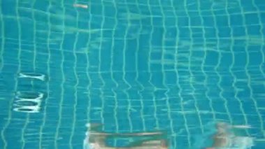 6 yaşında bir kız tatil köyünde havuza atlıyor.