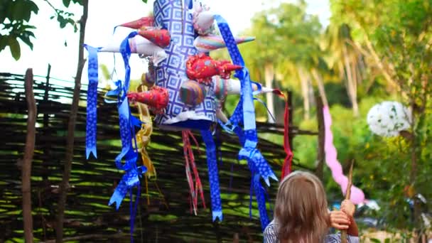 Niña de 7 años rompe una piñata de vacaciones — Vídeo de stock