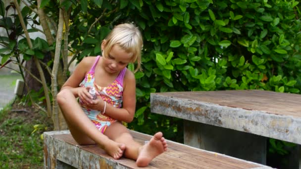 Un niño en los trópicos trata la piel con repelente de mosquitos — Vídeos de Stock