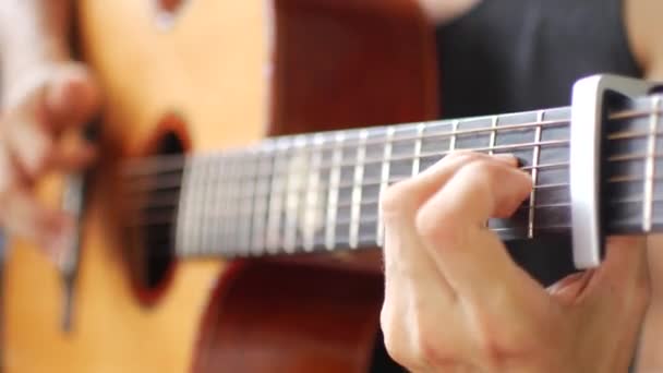 Gros plan sur le jeu de guitare acoustique, capo au 2nd fret — Video