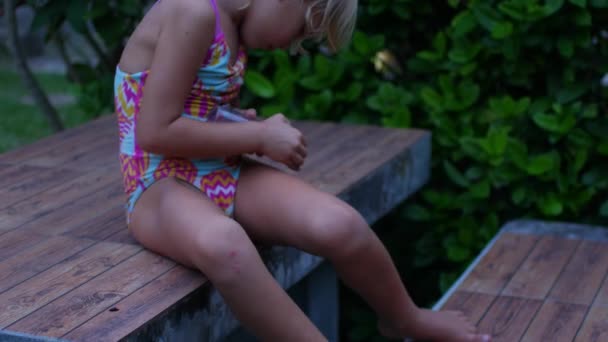 Een kind in de tropen behandelt de huid met muggenwerend middel — Stockvideo