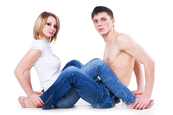 Casal de jeans sentado no chão — Fotografia de Stock