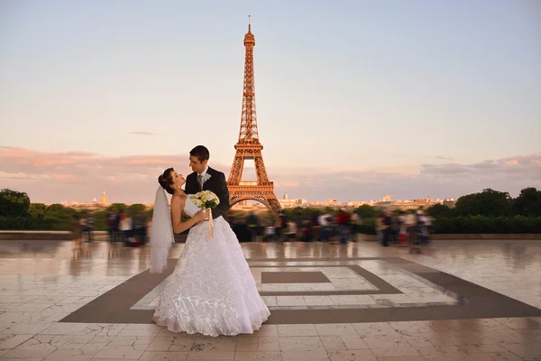 Beautiful wedding couple. Bride and groom in front of the Eiffel Tower in Paris. Retro Style