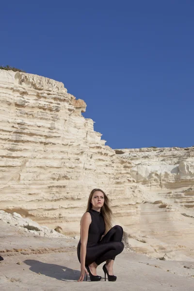 Femme en catsuit noir sur les rochers — Photo