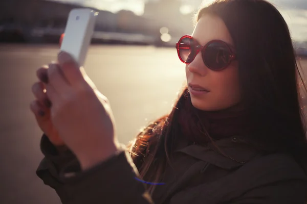 Hipster chica en gafas de sol tomar fotos con el teléfono inteligente — Foto de Stock