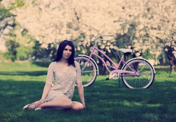 Menina branca nova com bicicleta no parque da mola — Fotografia de Stock