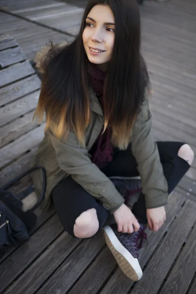 Hipster flicka i Parka Coat sitter utomhus — Stockfoto