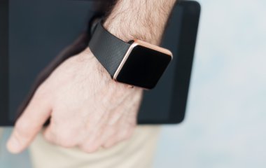 Elde akıllı saat ve elinde tablet pc