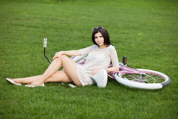 Jeune fille blanche avec vélo dans le parc de printemps — Photo