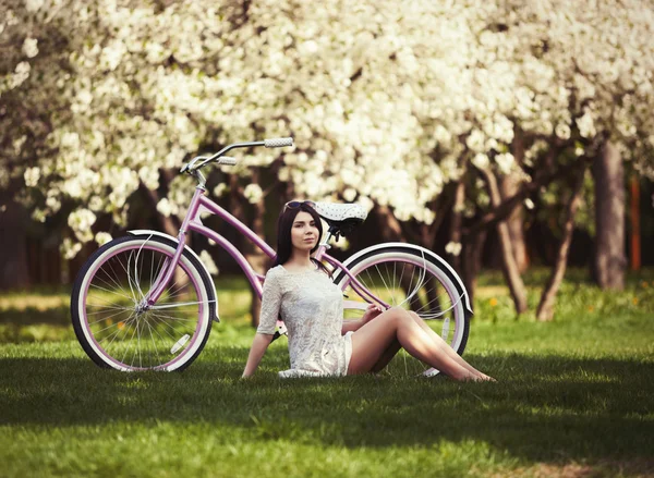 Jovem em sundress montando uma bicicleta no parque — Fotografia de Stock
