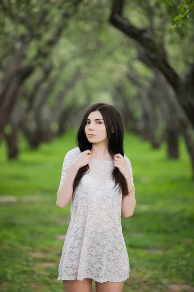 Carino ragazza in prendisole nel parco verde primaverile — Foto Stock