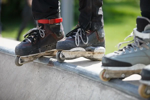 Rollerblader inline agressivo em pé na rampa no parque de skate — Fotografia de Stock