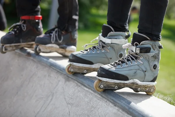 Rollerblader in linea aggressivo in piedi sulla rampa nello skatepark — Foto Stock