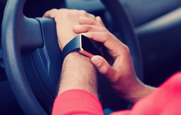 Handen van Afrikaanse man met behulp van slimme horloge in een auto zit — Stockfoto