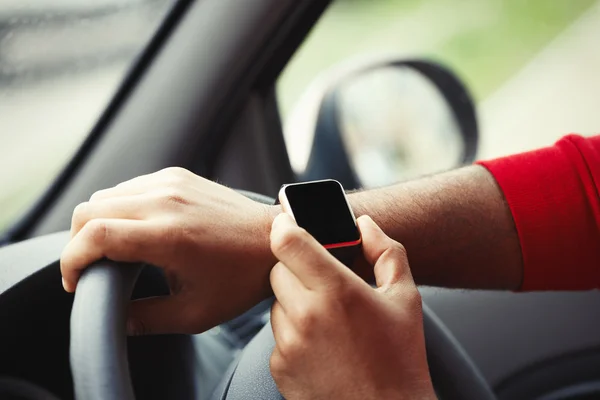 Hands of black man with smart wrist watch in car — Stock Photo, Image