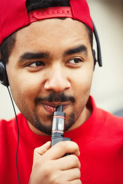 Dispositivo vaporizzatore e-sigaretta fumante giovane uomo nero — Foto Stock
