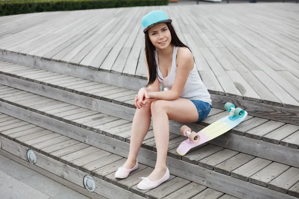 Jong meisje met korte cruiser skateboard dek buitenshuis — Stockfoto