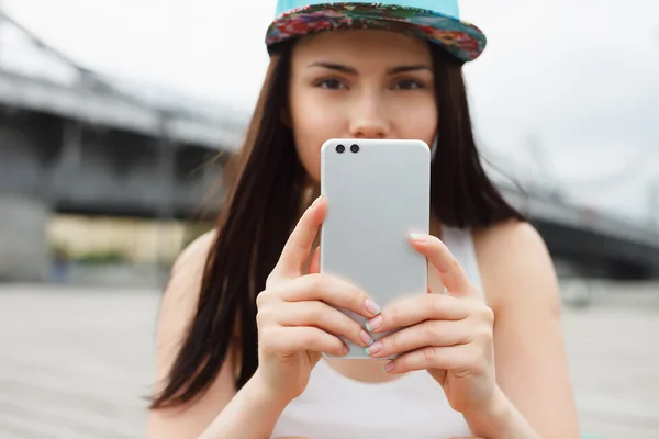 Girl takes photo with phablet smartphone with dual camera — Stock Photo, Image