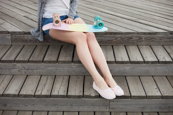 Pernas de menina com skate cruzador curto colorido — Fotografia de Stock