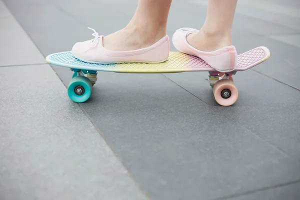 Pies de chica montando colorido cruiser corto monopatín — Foto de Stock