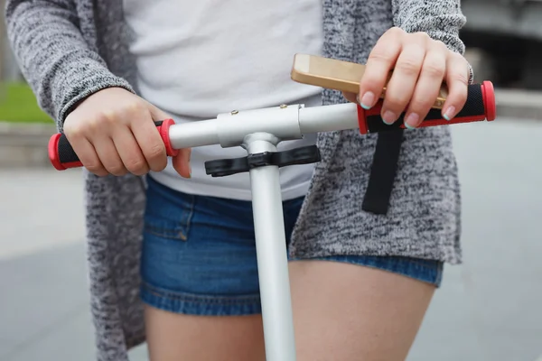 Young girl riding a scooter outdoors at day — Stock Photo, Image