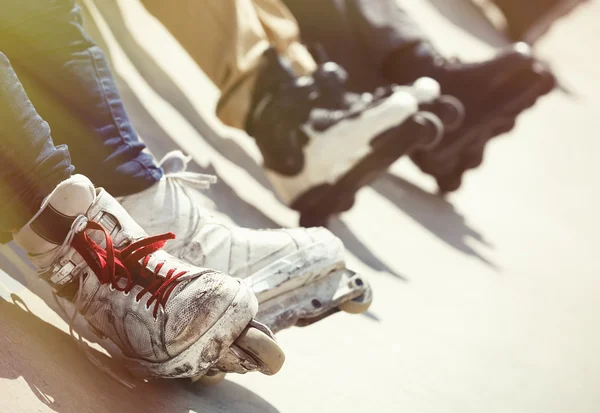 Aggressive inline rollerblader sitting on ramp in skatepark — Stock Photo, Image