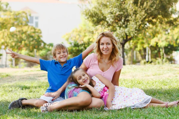 Young happy family having fun in green park — Stock Photo, Image