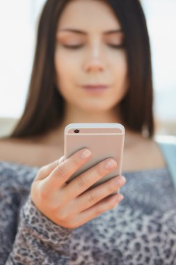 Büyük gümüş modern akıllı telefon kullanan esmer genç kız 