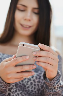 Büyük gümüş modern akıllı telefon kullanan esmer genç kız 