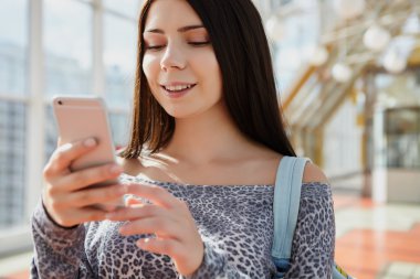 Esmer kız büyük modern akıllı telefon kullanarak 