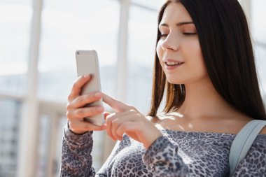 Esmer kız büyük modern akıllı telefon kullanarak 