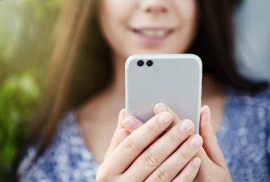 Kız modern çift kameralı akıllı telefon ile fotoğraf çekmek