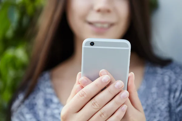 Girl taking photo with big silver smart phone — Stock Photo, Image