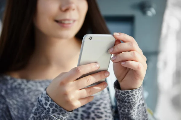 Brunetka, młoda dziewczyna, za pomocą duży srebrny nowoczesny inteligentny telefon — Zdjęcie stockowe