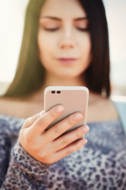 Büyük gümüş modern akıllı telefon kullanan esmer genç kız 