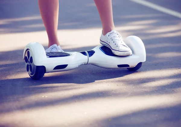 Pies de niña montando mini scooter eléctrico hoverboard —  Fotos de Stock