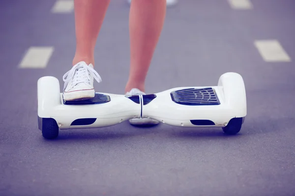 Piedi di ragazza in sella elettrico mini hoverboard scooter — Foto Stock