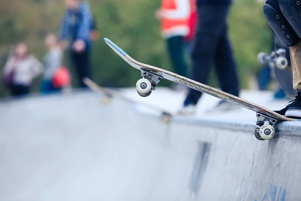 Skater sur skateboard debout sur la rampe en béton du skate park — Photo