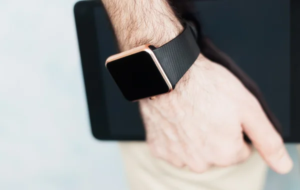 Smart Watch auf der Hand und Tablet-PC in der Hand — Stockfoto
