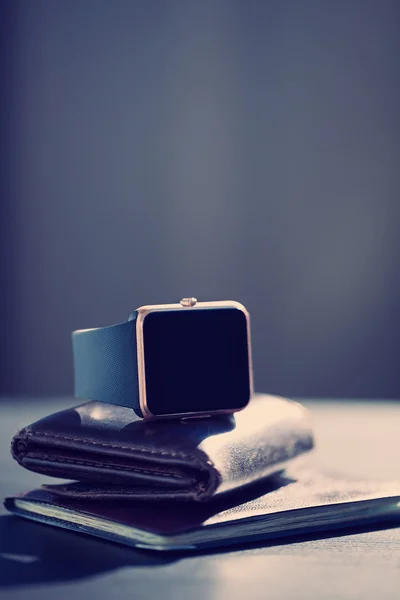 Reloj inteligente, billetera con monet, pasaporte sobre la mesa — Foto de Stock