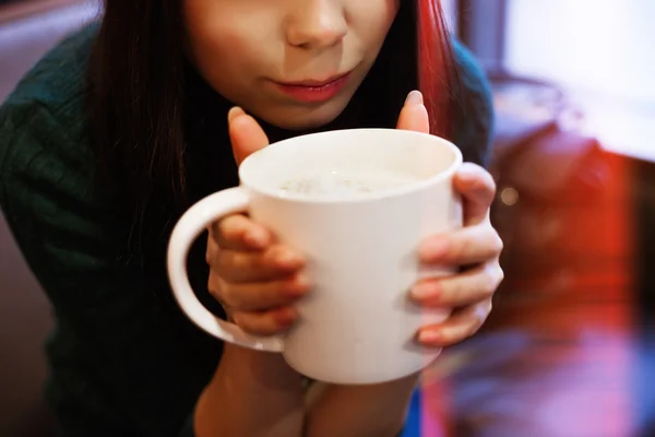 Молода жінка п'є велику чашку кави — стокове фото