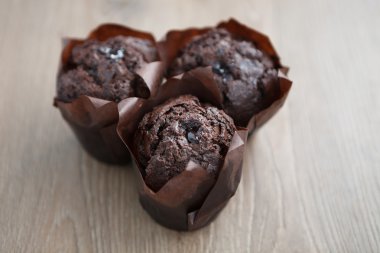 Ahşap masada üç lezzetli çikolatalı kekler