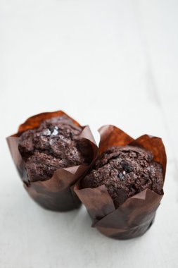 Ahşap masada iki lezzetli çikolatalı kekler