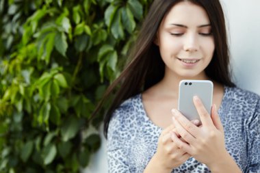 Kız modern çift kameralı akıllı telefon ile fotoğraf çekmek