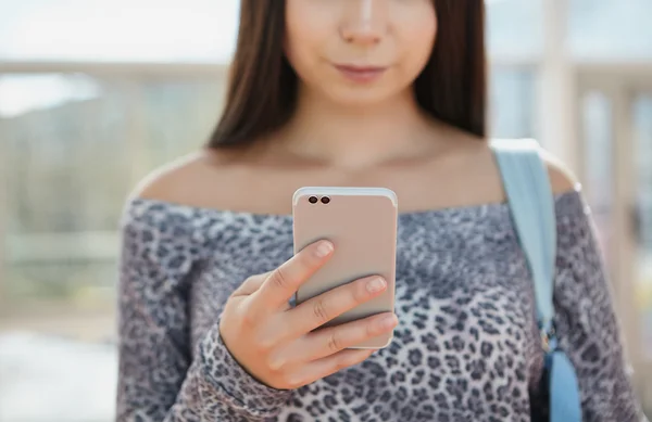 Молодая красивая модель с использованием современного смартфона с двумя камерами — стоковое фото