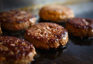 Fast food restoranının mutfağında et köftesi kızartılıyor. Yemek için leziz domuz filetosu. Hamburger için hazırlanıyor.