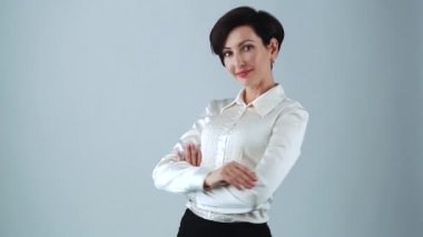 İpek gömlekli güzel beyaz iş kadını. Stüdyoda poz veren dost canlısı bir iş kadını görüntüsü. Resmi giyinmiş genç bir kadın model. 