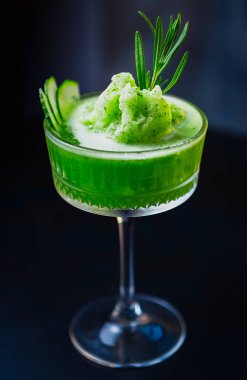 Bardakta taze biberiye kokteyli. Sert alkol, meyve suyu, salatalık ve biberiye ile servis edilen taze yeşil uzun içki.