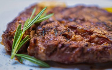 Restoranda akşam yemeği için nefis pirzola bifteği. Izgarada pişmiş gurme et, biberiyeli otla servis edilmiş.